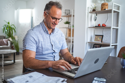 Middle aged Caucasian man working on laptop at home