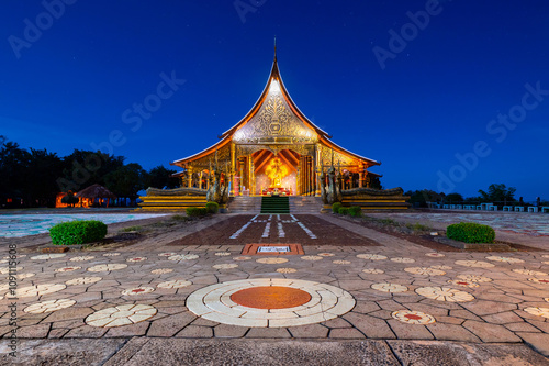 Beautiful Temple Sirindhorn Wararam Phuproud in Ubon Ratchathani Province at twilight time,Thailand.Thai temple at night and before sunset.Night sky effect for Long exposure fluorescent light. photo