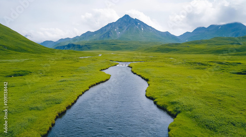 Serene Mountain Stream: A winding river carves its path through lush green meadows, with a majestic snow-capped mountain rising in the background. photo