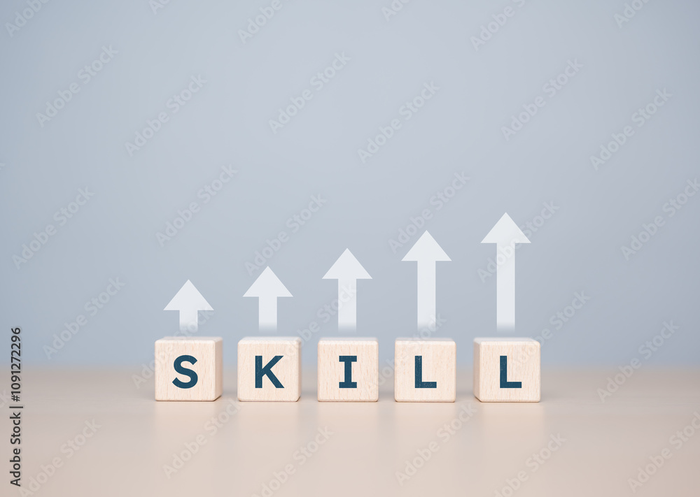 Wooden cubes with SKILL words with arrow-up icons. Upskilling and personal development concept. Upskill training, knowledge and education, learning, ability. Up-skilling or Re-skilling for new jobs. Wooden cubes with SKILL words with arrow-up icons. Upskilling and personal development concept. Upskill training, knowledge and education, learning, ability. Up-skilling or Re-skilling for new jobs.