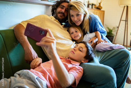 Happy family taking a selfie on the couch at home photo