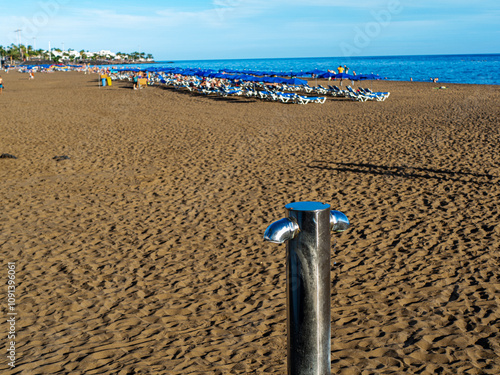 Silver Beach Shower with Vacation Vibes on a Large Tourist Beach

