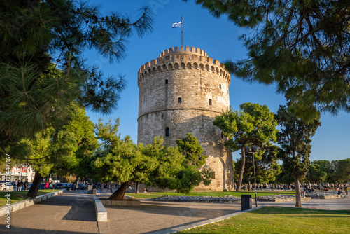 Thessaloniki's Iconic White Tower Surrounded by Lush Greenery on a Bright Summer Day