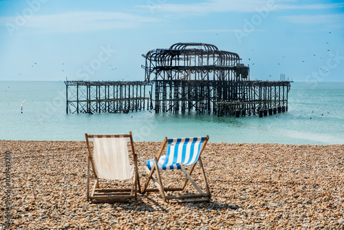 Zwei Klappstühle am Strand vor der Ruine des abgebrannten West Pier in Brighton, East Sussex, England photo