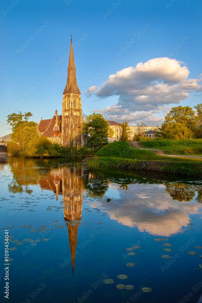 There is a reflection of gothic church in water by the lake There is a reflection of gothic church in water by the lake