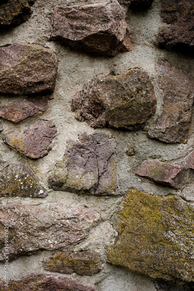 A wall made of stone with a rough texture. The wall is brown and white