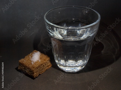 Poverty and hunger. Water in a glass, bread with salt. Beggar's food. photo