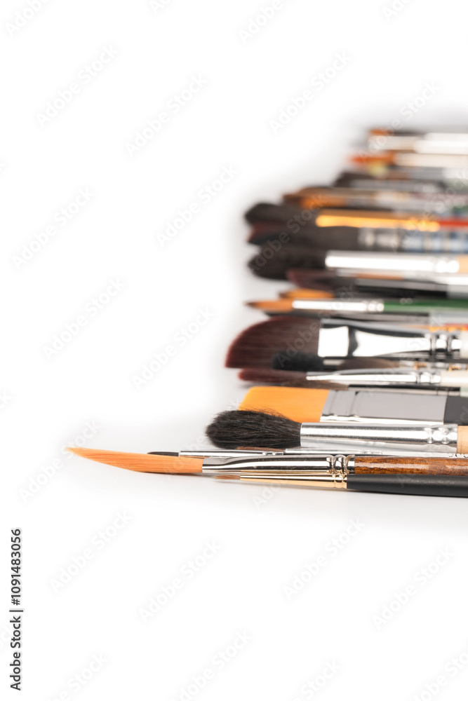 Obraz premium Mix of paint brushes in a row isolated on a white background.