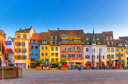 Mulhouse cityscape, typical houses colorful buildings and street restaurant outdoor café on Place de la Reunion square in old town Mulhouse city historic centre, Alsace Grand Est region, France