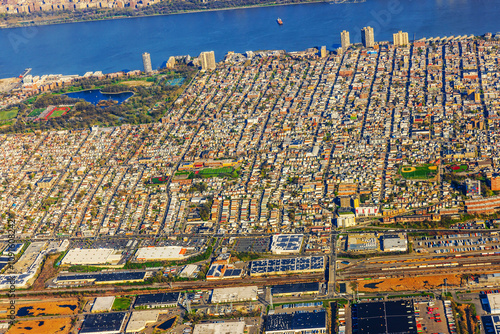 Aerial view of densely populated urban area with residential buildings, green parks and Hudson River in background. New York. USA.