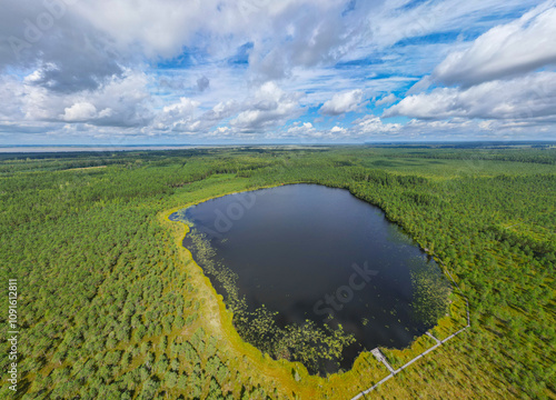 Drone Shot as Panorama over Lake Teirumniku on the Teirumniki bog path, Teirumniku purva taka, summer view of the lake with forest in the background in the swamp and bog area in Latgale, Latvia