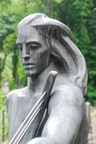 Photograph of a monument, a sculpture of a female musician playing the harp, near the Lychakiv Cemetery in Lviv, Ukraine. photo