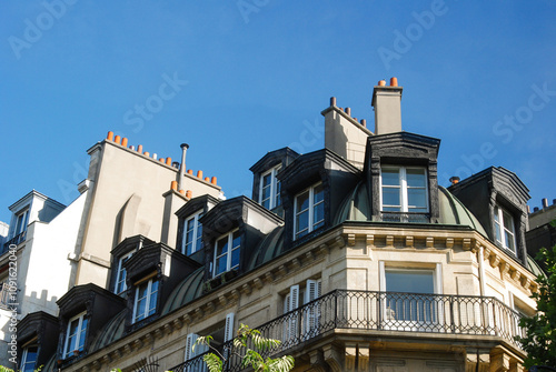 Facade of a house, building in Paris, the capital of France, with a balcony, veranda. Photograph of ancient architecture in Europe.