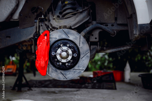 Large brake discs and large calipers provide better braking.The large calipers mesh properly with the discs.Car wheel and brake system.Red caliper.