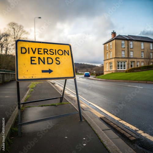 Cardross, Dumbarton, Scotland UK, 2024-16-05: Diversion ends sign (UK), yellow sign, black text, indicates diversion ended. It is placed on a street next to a road. Building and car in the background photo