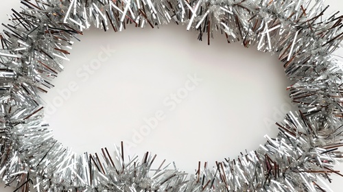 Chic Christmas card design featuring a silver tinsel garland circling around a central white space, perfect for a festive message.