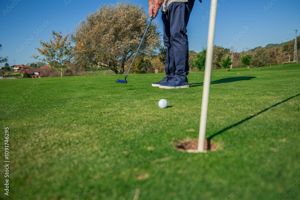 Obraz premium copyspace golf ball rolling toward the hole on the green after being hit by a unrecognized golfer