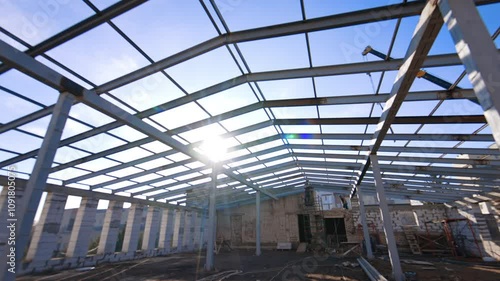 Wallpaper Mural Large spacious attic with the frame of a future roof. Worker is welding metal balks. Low angle view. Torontodigital.ca