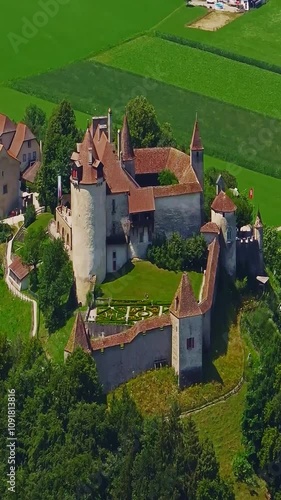 Medieval Swiss castle aerial view in summer. A drone flies through a green valley in the Swiss mountains. Famous Gruyere castle in Switzerland also called Schloss Greyerz, aerial shot by drone photo