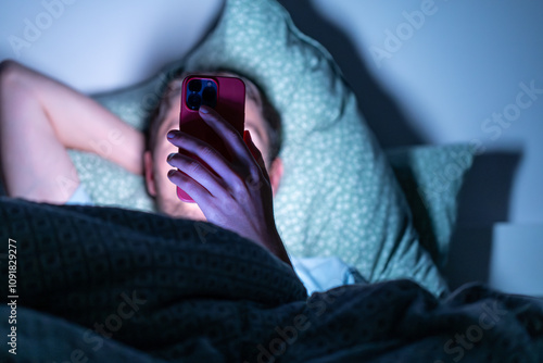 man with phone in bed in the dark, using phone before sleep, using phone before sleep. phone device addiction, screen time	 photo