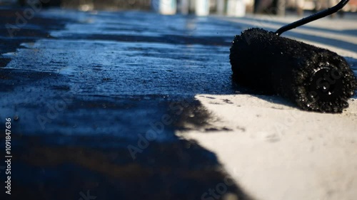 Flat roof waterproofing preparation using mastic primer close up by professionals