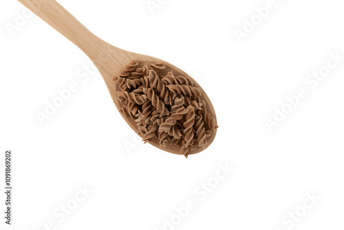 Pasta di Lino in wooden spoon, close-up. Design element. Flaxseed gluten free pasta. Fusilli made from flax and corn flour. Low glycemic index food