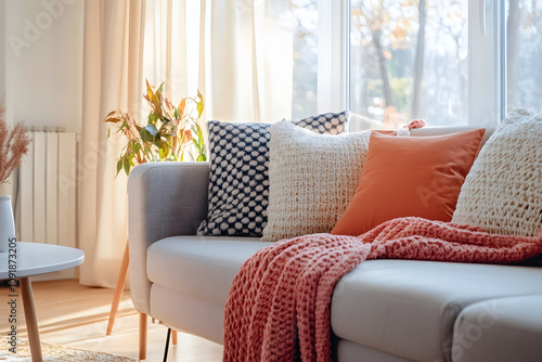 Energizing Sunset Coral Living Room Decor with Cozy Textiles and Natural Light photo