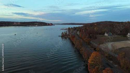 Wallpaper Mural A low altitude drone view of empty train tracks by the Hudson River in the Hudson Valley on a cloudy evening in autumn. The camera dolly in over the water by the river bank. Torontodigital.ca