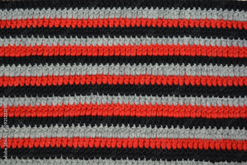 Striped crochet pattern made from red, black and white yarn Striped crochet pattern made from red, black and white yarn