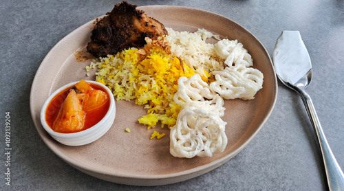 Grilled chicken mandhi dish with basmati rice, crackers, fermented pineapple  photo