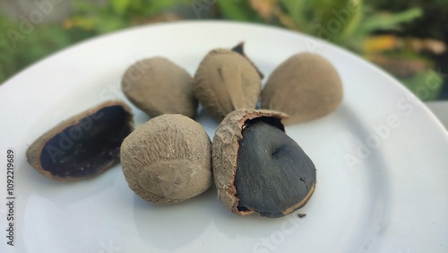 Keluak, also known as Keluwek or Keluwak or Kluwak is the seed of the Pangi or Kepayang tree ( Pangium edule ). It main spice to make Rawon Soup, Indonesian black beef soup . photo