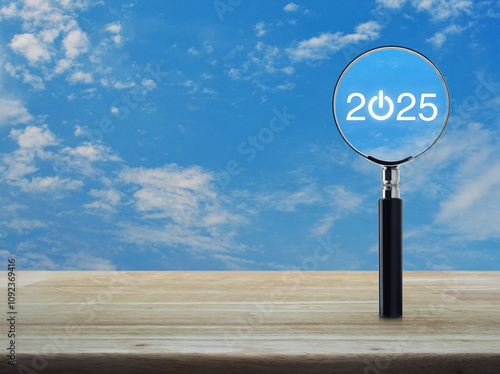 2025 start up flat icon with magnifying glass on wooden table over blue sky with white clouds, Business happy new year 2025 success concept