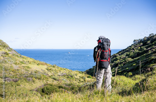 Backpacker hiking Cape Brett Track. Bay of Islands. New Zealand.