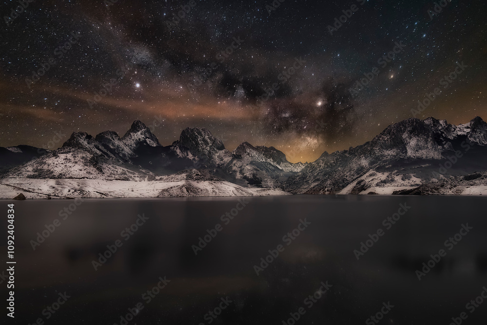Fototapeta premium View of the town of Riaño, Leon, covered in snow at night with the reservoir and mountains in the background