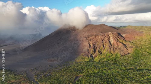 Smoke from active volcano in Tanna Island, Vanuatu. Drone pull back, sunset, golden hour landscape. photo