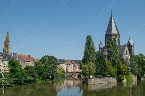 Le temple protestant à Metz avec la Moselle qui coule au premier plan, ciel bleu et soleil photo