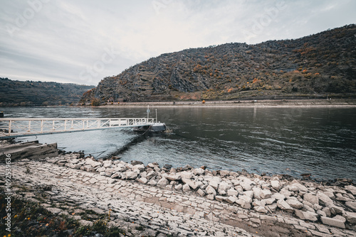 Steg am Flussufer mit Blick auf bewaldete Hügel im Herbst photo