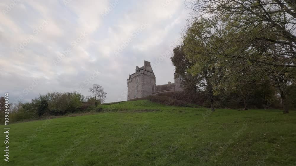 Historic Château du Bouchet in rural France surrounded by green fields under a cloudy sky Historic Château du Bouchet in rural France surrounded by green fields under a cloudy sky