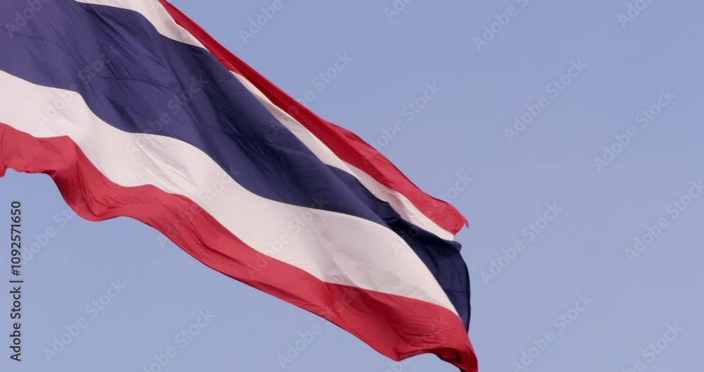 Thai flag waving freely in the air amidst the clear blue skies background. Thai flag waving freely in the air amidst the clear blue skies background.