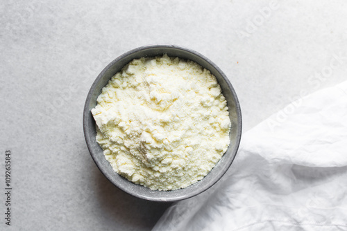 Overhead view of powdered milk in a grey bowl, top view of full fat milk powder in a bowl photo