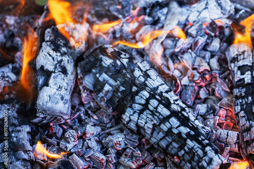 Glowing embers in hot red color, abstract background. The hot embers of burning wood log fire.