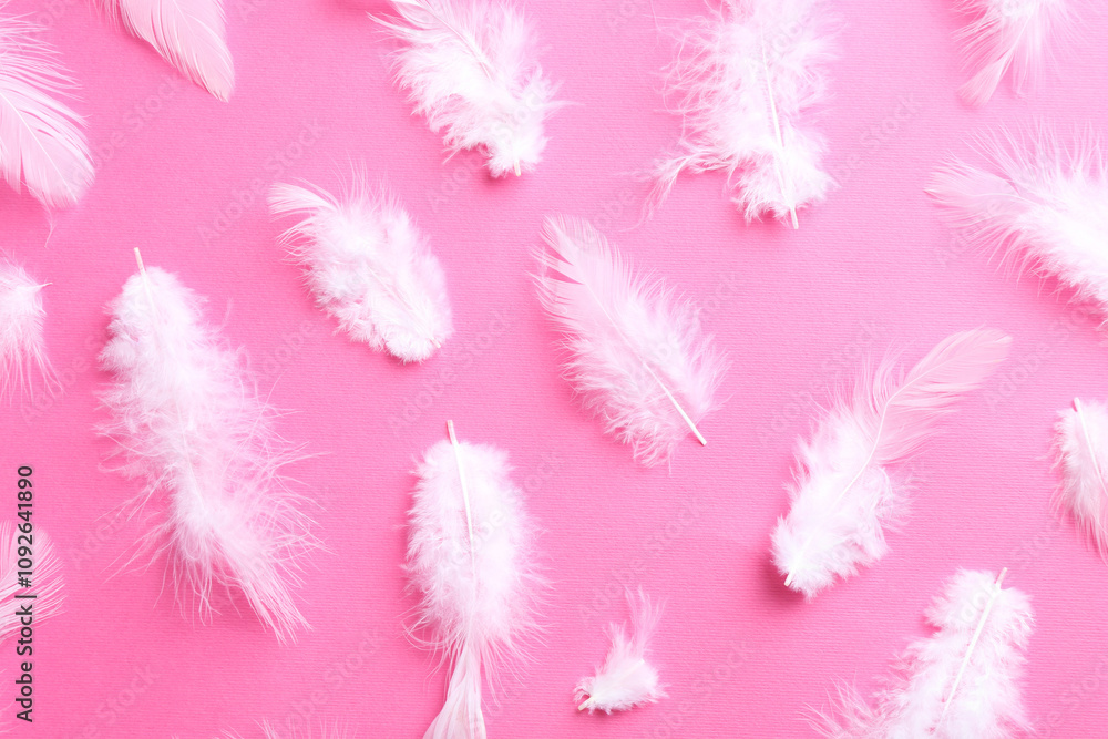 Obraz premium Many fluffy feathers on pink background, flat lay