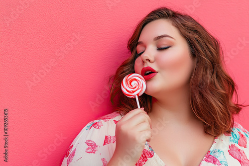 Plus-size girl enjoying a lollipop in a playful pose photo