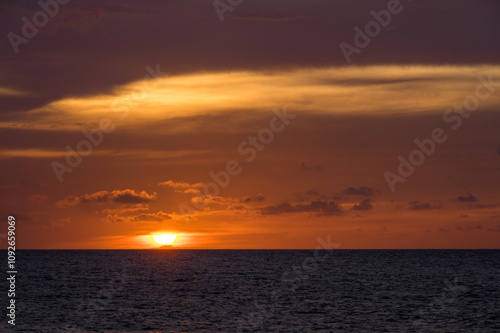 Tranquil ocean sunset with vibrant sky and gentle waves