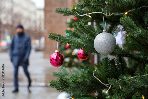 New Year celebration in city, Christmas tree with decorations on a street on blurred people background