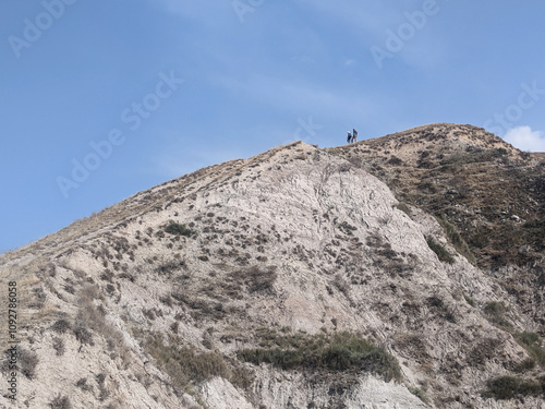 View of landcape with mountains and hills. Tourists sit on the top of the mountain. Vivid natural scenery photo, travel photo.