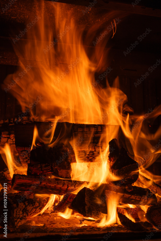 Bright flames and glowing embers consuming stacked firewood in a fireplace, long exposure shot Bright flames and glowing embers consuming stacked firewood in a fireplace, long exposure shot