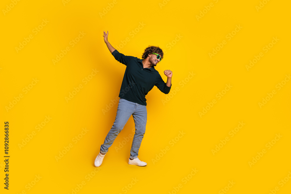 Young man in casual attire joyfully dancing against a vibrant yellow background, embodying joy, energy, and youthful spirit. Young man in casual attire joyfully dancing against a vibrant yellow background, embodying joy, energy, and youthful spirit.