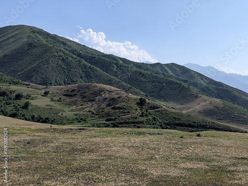 View of landcape with mountains and hills. Beautiful clouds above mountains. Vivid natural scenery photo.