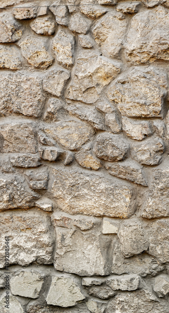 Texture wall stone sandstone with shadows and deep pattern. Vertical shot banner. Clinker tiles or bricks on the wall in the form of wild stone Texture wall stone sandstone with shadows and deep pattern. Vertical shot banner. Clinker tiles or bricks on the wall in the form of wild stone